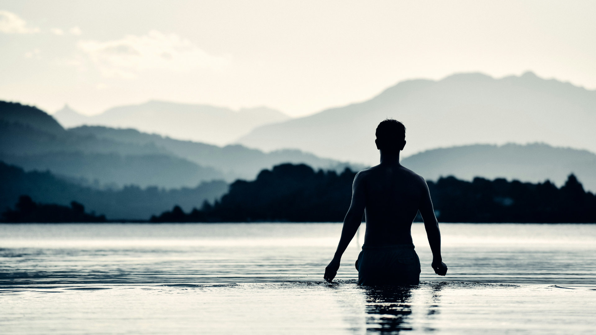 A person standing in soft daylight, eyes closed, taking a calm breath