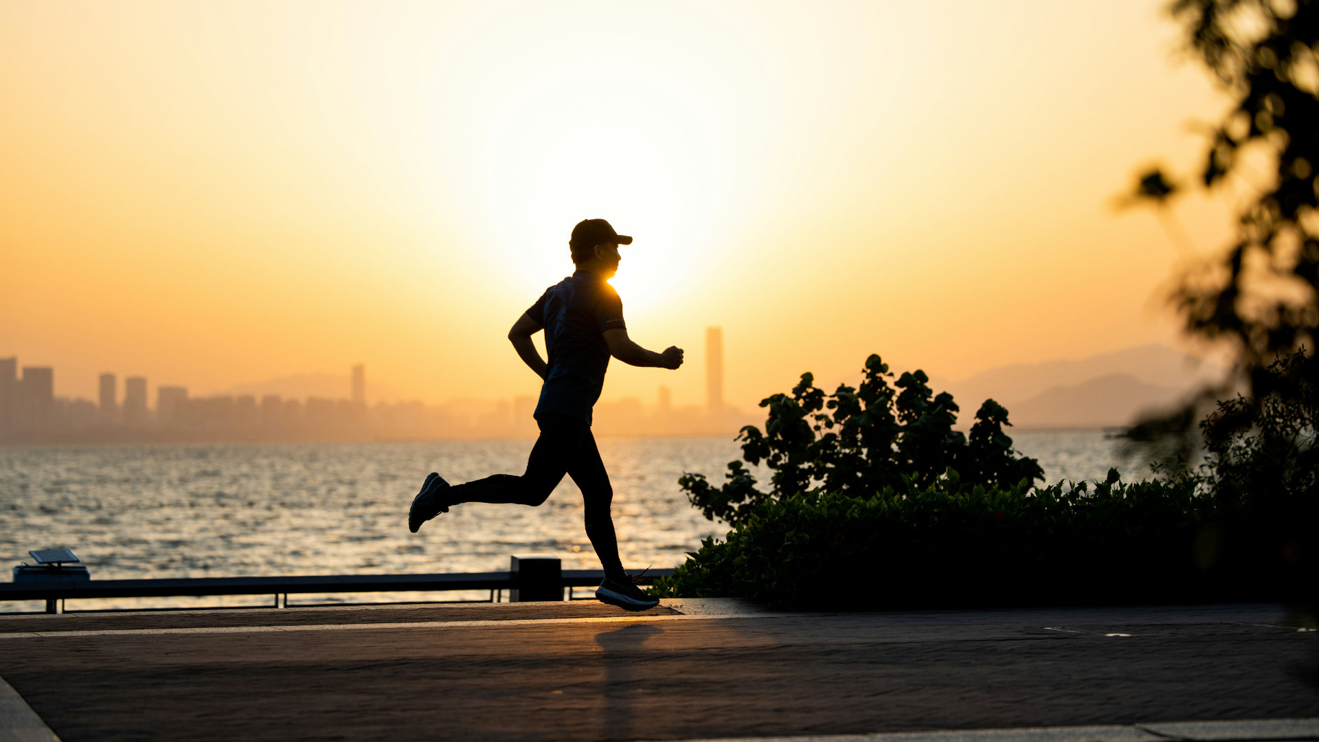 A runner in motion on a track or trail at golden hour, focused and strong