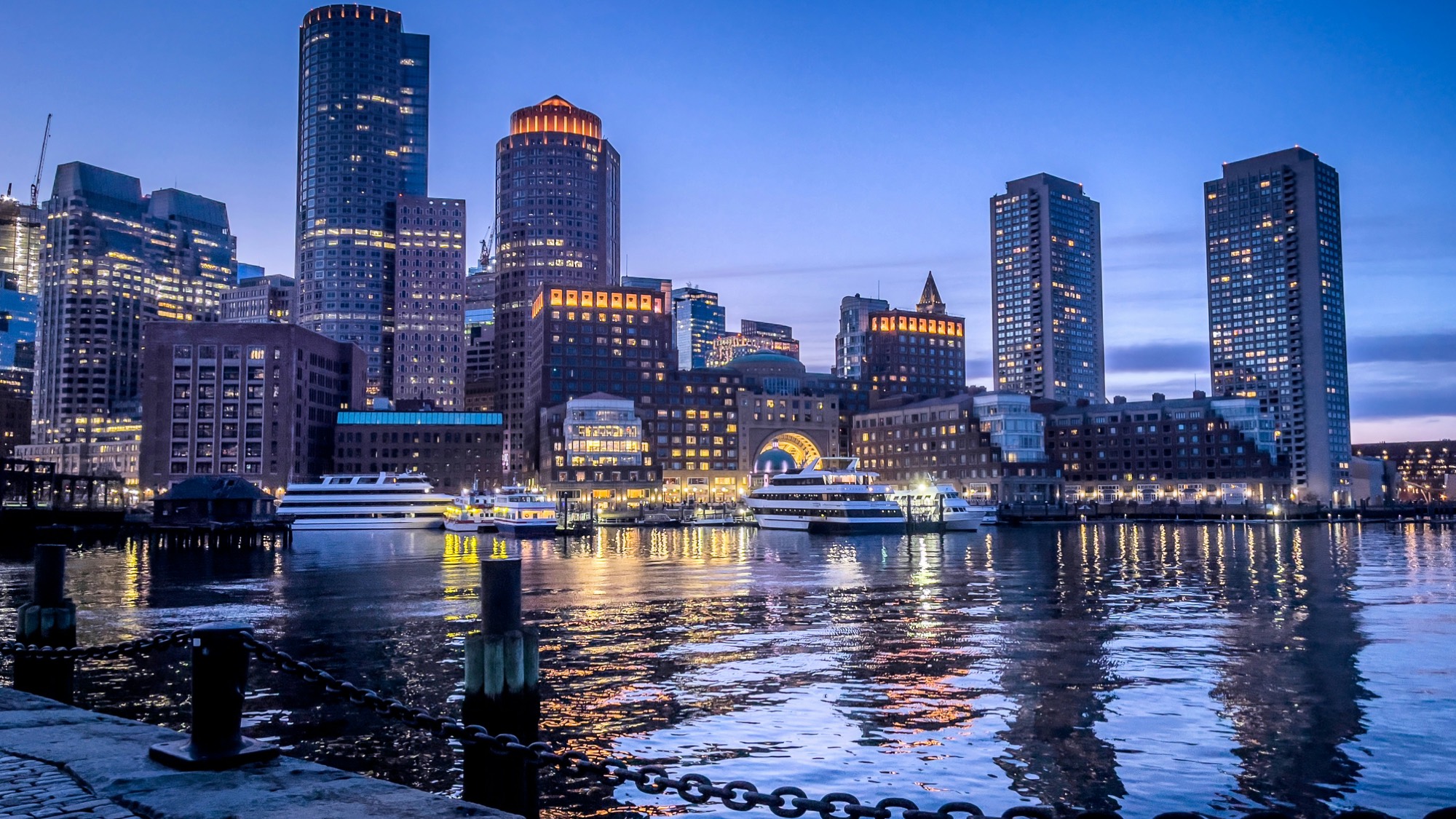 The Boston skyline reflected in the harbor at blue hour